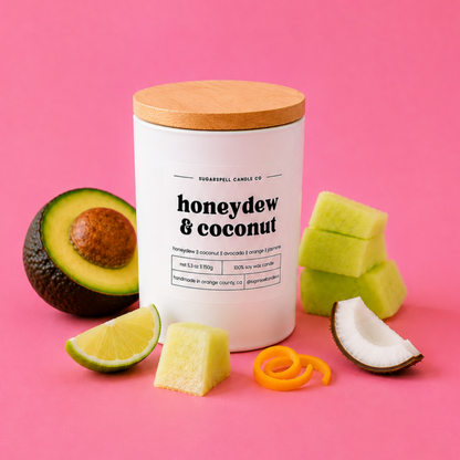 Handmade Honeydew & Coconut candle in an open white jar with fruit accents