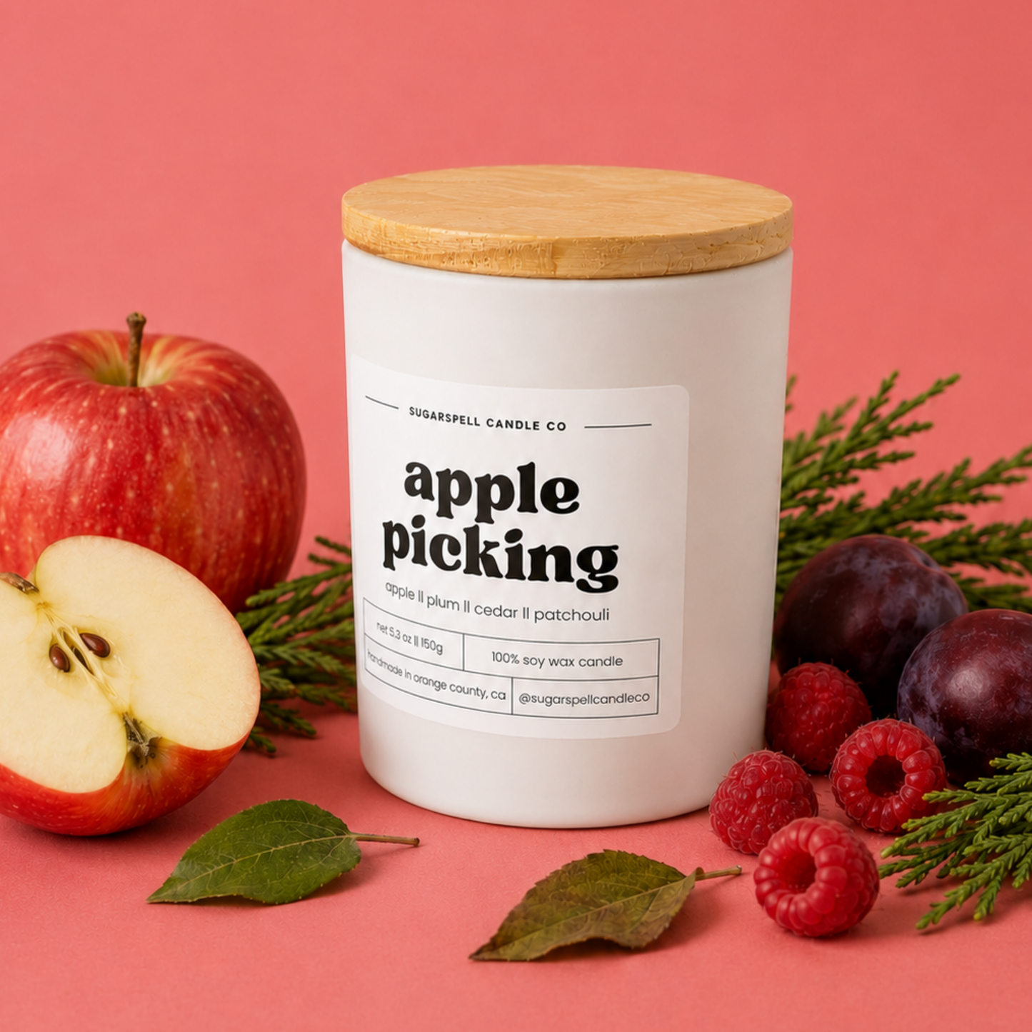 Handmade Sugarspell Apple Picking soy candle styled with apples and cedar sprigs