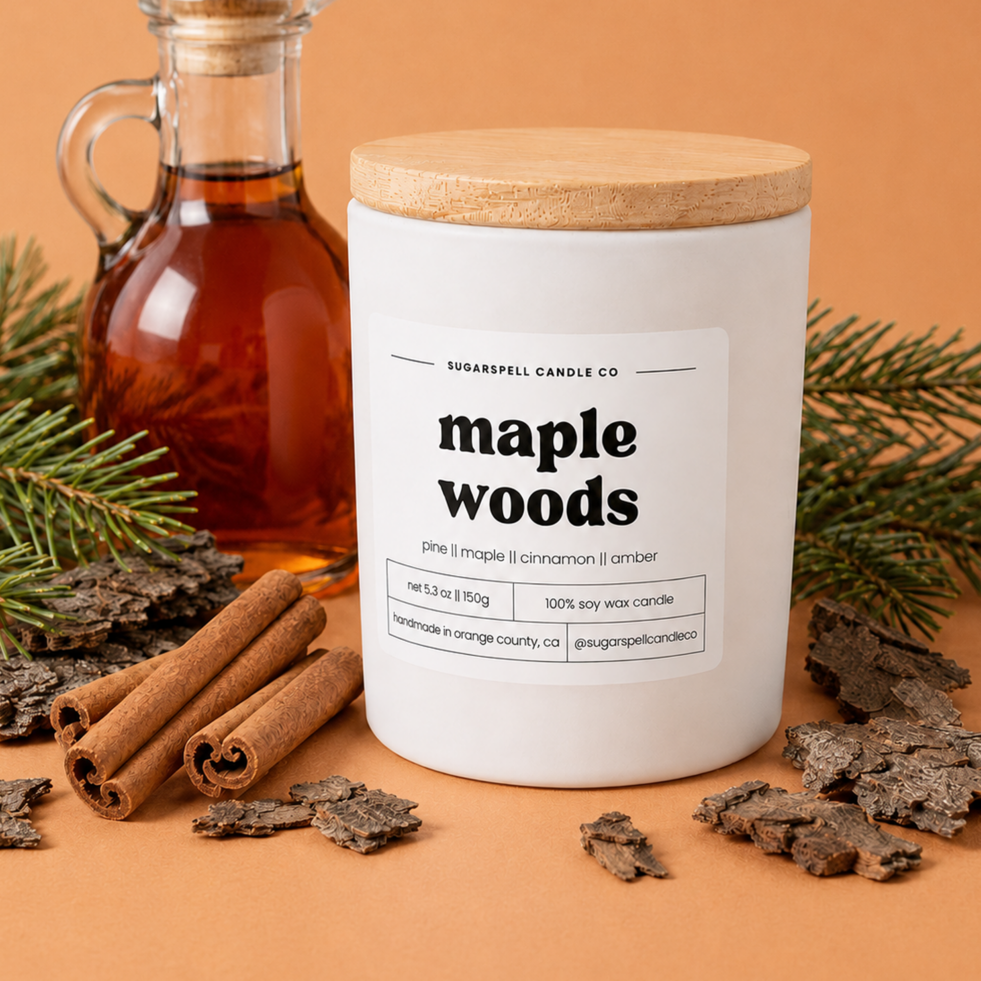 Handmade Maple Woods candle in an open white jar with pine sprigs and bark