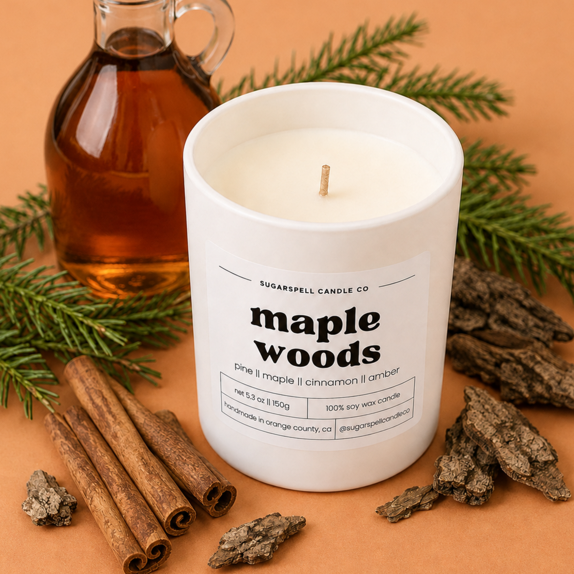 Handmade Sugarspell Maple Woods soy candle styled with pine, syrup and cinnamon