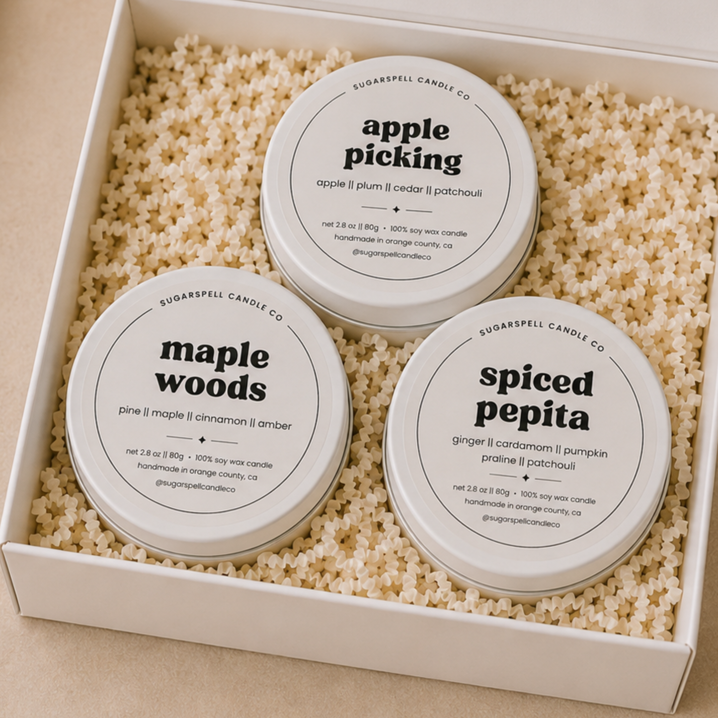 Open Scenic Route gift box with three handmade mini candle tins nestled in crinkle paper